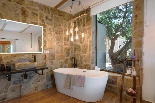 a bathroom with a tub and a stone wall at Laurelin in Candelaria