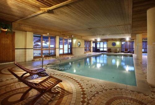 une grande piscine dans un immeuble avec un banc dans l'établissement Appartement chaleureux 4-6 pers Chalet Chamois appt H2, à Arc 2000