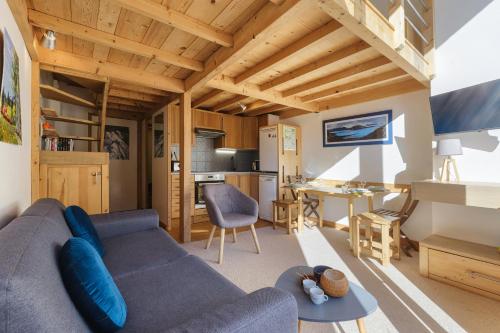 un salon avec un canapé bleu et une table dans l'établissement Résidence Grand Roc - Campanules 413 - Happy Rentals, à Chamonix-Mont-Blanc