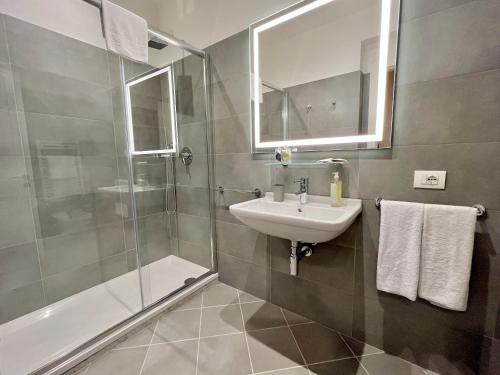a bathroom with a sink and a shower and a mirror at The Seven Suites in Genova