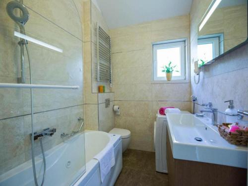 uma casa de banho com uma banheira, um lavatório e um WC. em 4B apartments Dubrovnik em Dubrovnik