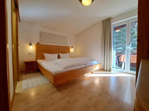 a bedroom with a bed and a large window at Haus Kaunergrat in Kaunertal