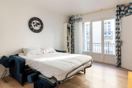 une chambre avec un lit et une grande fenêtre dans l'établissement Chez Fitia T2 à Nantes Centre, à Nantes