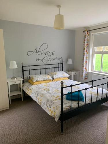 a bedroom with a bed with a sign on the wall at Serenity Cottage in Lisnaskea