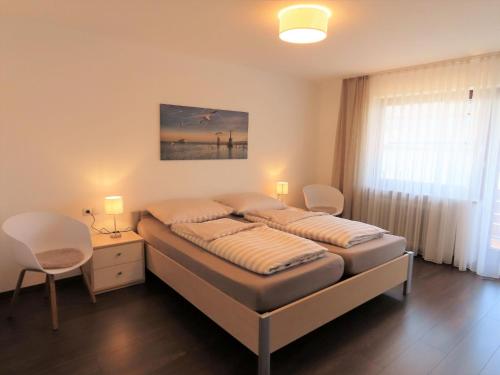 1 dormitorio con 1 cama, mesa y sillas en Ferienwohnung Ankerplatz 1 en Immenstaad am Bodensee