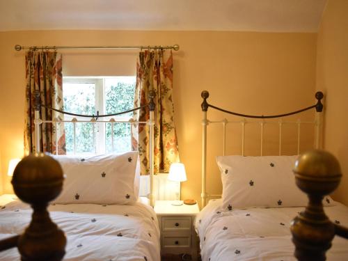 - une chambre avec 2 lits et une fenêtre dans l'établissement Church View Cottage, à Ashbourne