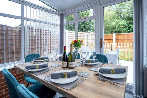 a dining room table with wine bottles and glasses at Yew Tree House Contractor / Family home Free Netflix Fast WiFi near Dudley/Birmingham in Old Hill