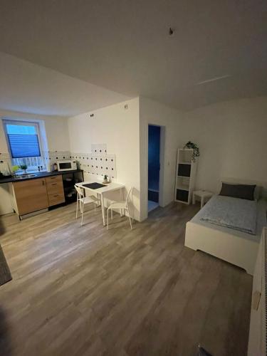een slaapkamer met een bed en een tafel en een keuken bij Ruhiges Apartment im Herzen von Gera in Gera