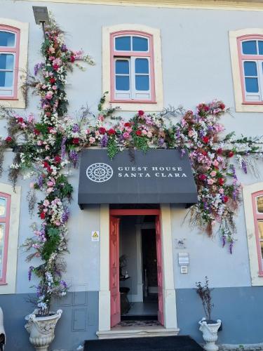 a building with flowers on the side of it at Guest House Santa Clara in Coimbra