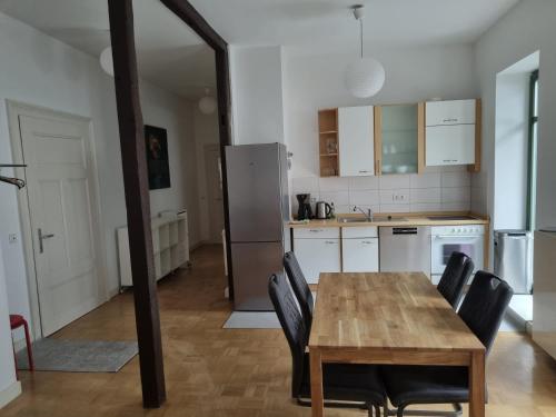 une cuisine avec une table en bois et des chaises noires dans l'établissement Cosy Apartment City Center, à Leipzig