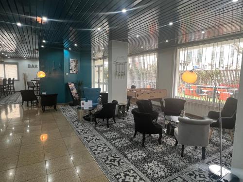 a lobby with chairs and tables and a piano at Hôtel Saphir Lyon in Lyon