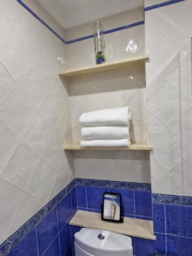 a bathroom with blue and white towels and a toilet at Villa D&D in Torrox Costa