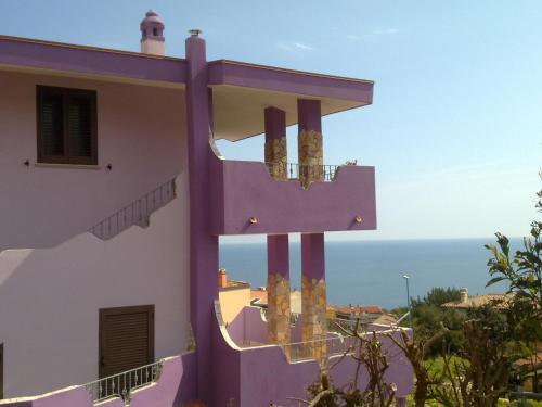 un edificio púrpura con vistas al océano en Casa Purple, en Cala Gonone