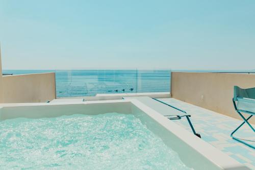 a swimming pool with a chair and a table and a chair at Hotel Saline in Palinuro