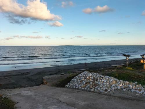 a view of the ocean with a pile of rocks on the beach at Casa Suite Palmar del viento FRENTE, FRENTE AL MAR by Amauna in Moñitos