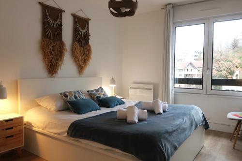 een slaapkamer met een groot bed met blauwe kussens bij LE CLOS SAINT MICHEL 2 - 6 personnes, Centre, Parking in Annecy