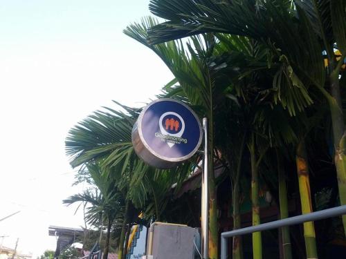 a sign on a pole next to some palm trees at Goodmorning by Tamarind in Phra Nakhon Si Ayutthaya