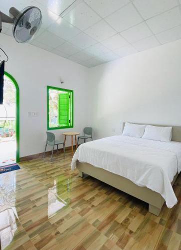 a bedroom with a bed and a table and chairs at Bao Dien Guesthouse in Bao Loc