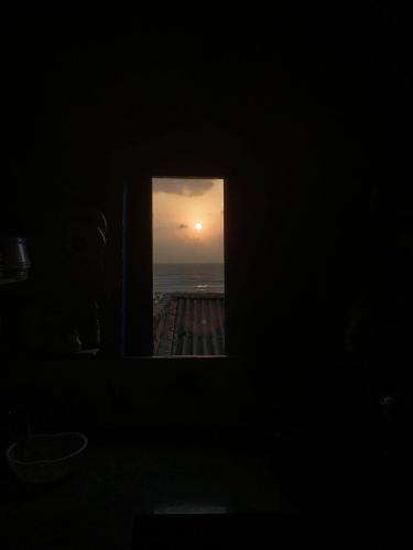 a window in a dark room looking out at the sunset at nhà Ba cơm Má in Phương Phi