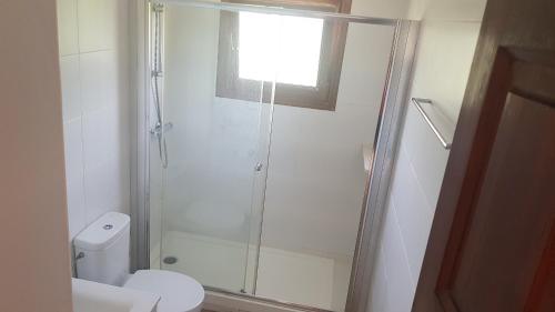 een badkamer met een glazen douche en een toilet bij Palmeres in Torroella de Montgrí