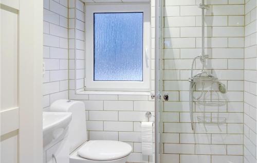 a white bathroom with a toilet and a window at Amazing Home In Kvidinge With 2 Bedrooms And Wifi in Kvidinge
