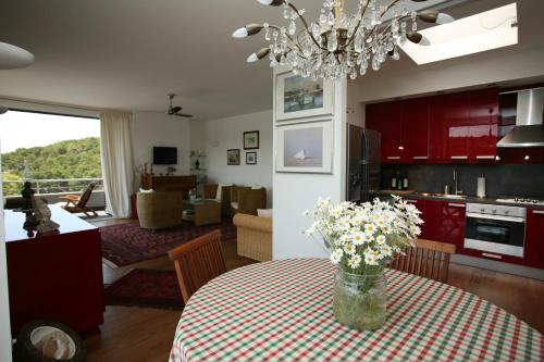 una cocina y una sala de estar con una mesa con flores. en Vila Filipovic, en Milna