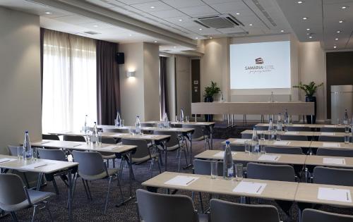 a conference room with tables and chairs and a screen at Samaria Hotel in Chania Town
