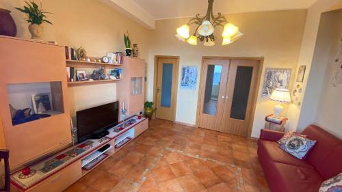 salon z kanapą i telewizorem w obiekcie Nice Sicily Little family home w mieście Acireale