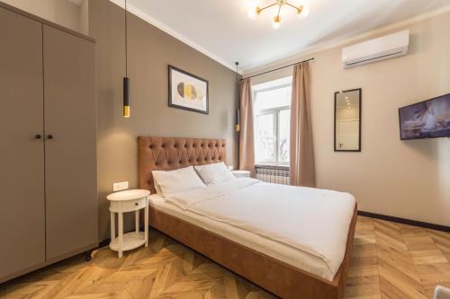een slaapkamer met een bed, een tafel en een raam bij Design Apartment on Mykhailivskyi Ln. 4 in Kiev