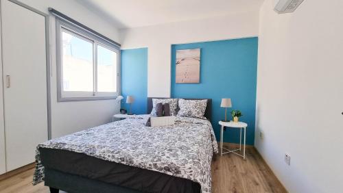 een slaapkamer met een bed en een blauwe muur bij Modern Retreat: 2br Stylish Apt with Comfy Rooms! Smart TV with 200MBPS Internet in Larnaka