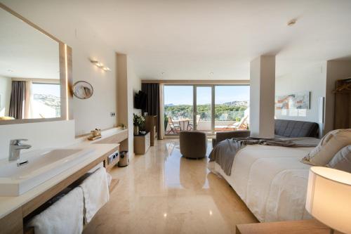 ein Schlafzimmer mit einem großen Bett und einem Waschbecken in der Unterkunft La Sort Boutique Hotel in Moraira