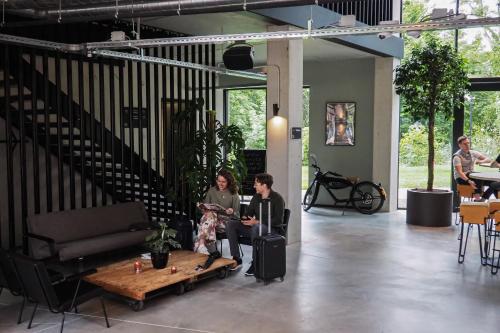 Dos personas sentadas en una habitación con una mesa en Hotel Valkenburg by Mercure - Next to Shimano Experience Center en Valkenburg