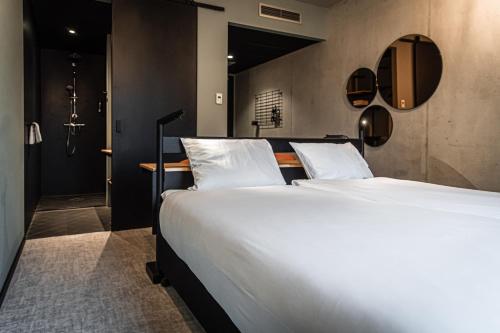 een slaapkamer met een groot bed met witte lakens bij Hotel Valkenburg by Mercure - Shimano Experience Center in Valkenburg