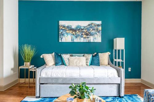 a living room with a blue wall and a couch at Call it Comfy in Houston