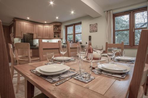 a dining room table with plates and glasses on it at Llais Afon - 3 Bedroom Holiday Home - Fishguard in Fishguard