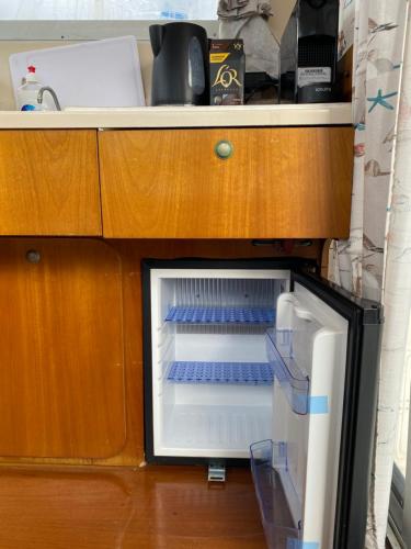 a refrigerator with its door open under a counter at Nuit insolite à bord du bateau Exocet III in Boulogne-sur-Mer