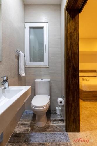 a bathroom with a toilet and a sink and a bed at Gozo - Apartment with Stunning Views & Shared Pool in Xagħra