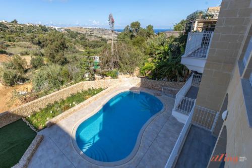 a swimming pool in the backyard of a house at The Grove Valley Views Apartment w/ Communal Pool in Xagħra