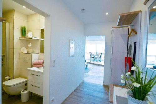 ein Badezimmer mit einem WC, einem Waschbecken und einem Spiegel in der Unterkunft Am Sahlenburger Strand AS01 in Cuxhaven