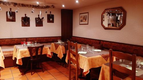 a dining room with two tables and a mirror at Hôtel Restaurant Aux Deux Roses in Neuf-Brisach