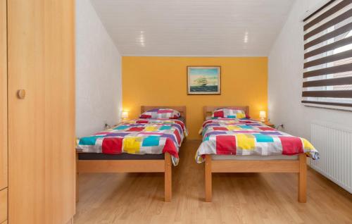 two twin beds in a room with yellow walls at Apartments Sweet Home in Otočac