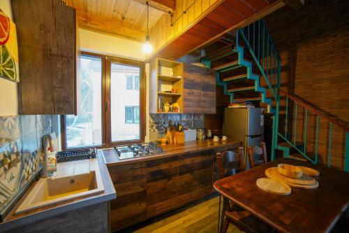 una cocina con escalera y una mesa con pan en Sakudela, en Nikortsminda