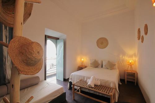um quarto branco com uma cama e uma janela em Riad Pierres et Saveurs Soleil em Marrakech