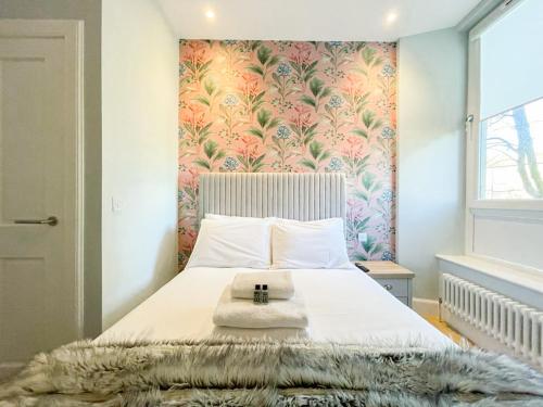 a bedroom with a large bed with a floral wallpaper at Beautiful 2BR, Private Entry in Vibrant Leith in Edinburgh