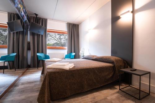 a hotel room with a bed and blue chairs at Hotel Ciclamino in Pietramurata