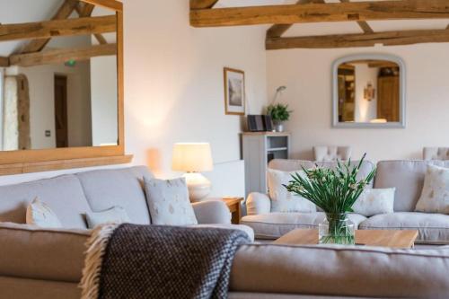 a living room with a couch and two chairs at Groves Barn at Norton Grounds in Chipping Campden