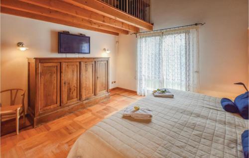 ein Schlafzimmer mit einem Bett und einem TV an der Wand in der Unterkunft Stunning Home In Fumane -vr- With Kitchen in Fumane