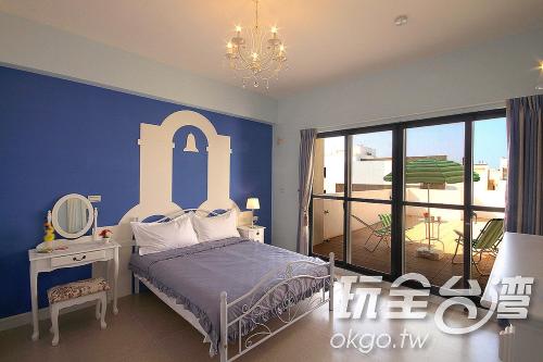 1 dormitorio con 1 cama con pared azul en Love 3 cubed, en Magong