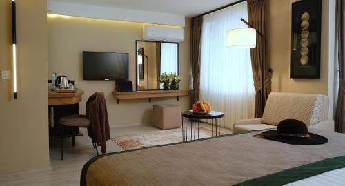 Casa De Port Hotel İstanbul في إسطنبول: غرفه فندقيه سرير وتلفزيون