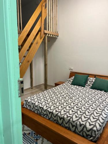 a bedroom with a bed and a wooden staircase at Alzira bonita Habitación verde con baño privado in Alzira
